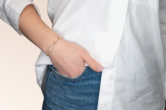 Brățară placată cu aur 18 K Dana, model cu bilute si perlute albe de plastic , lungime 19 cm.